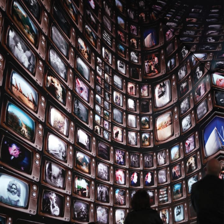 A wall of digital screens with various images on them.