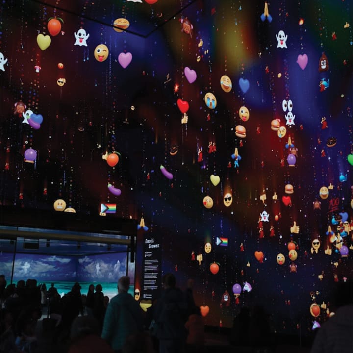 Walls with digital screens with various emojis on them.