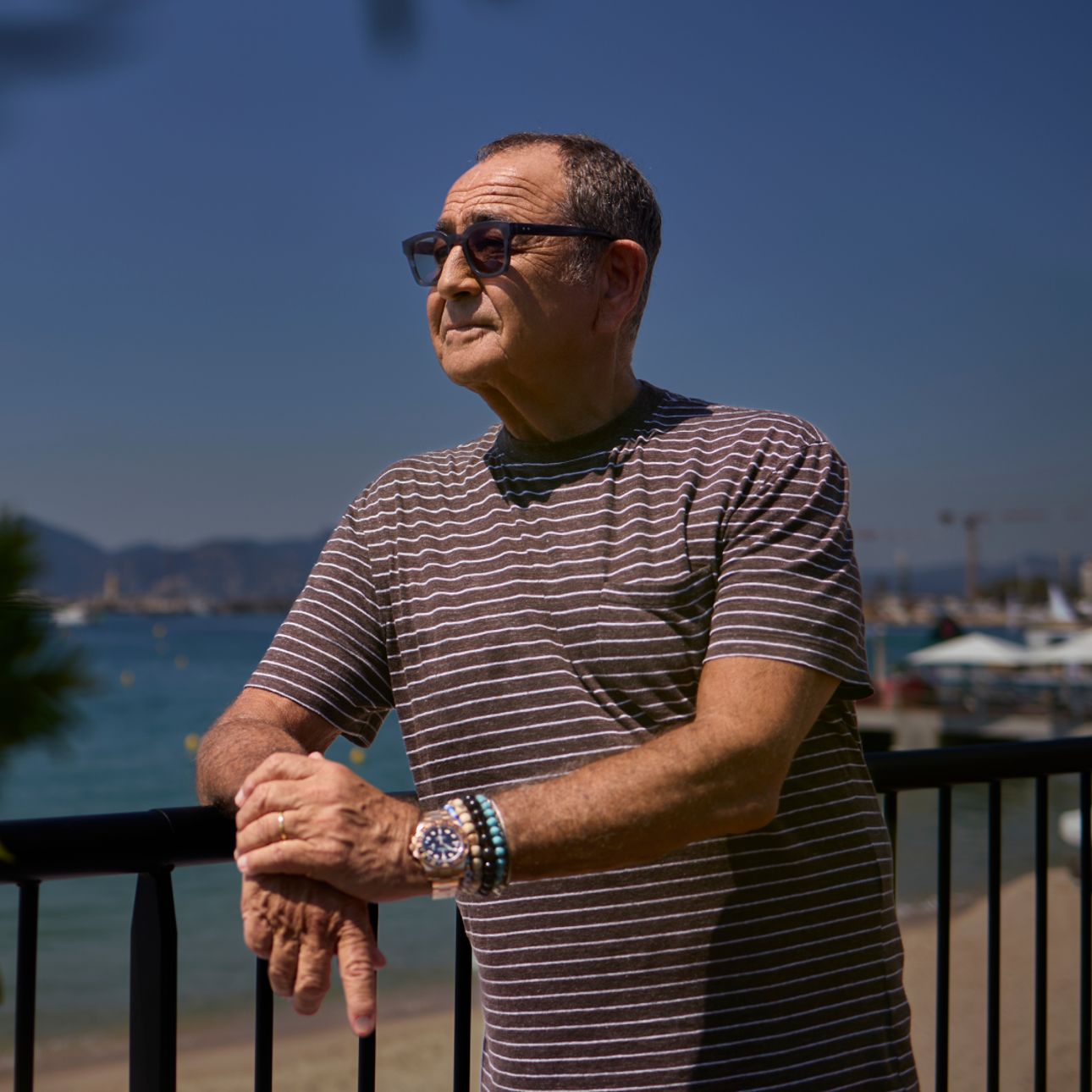 Michael Kassan leaning on a fence by the beach