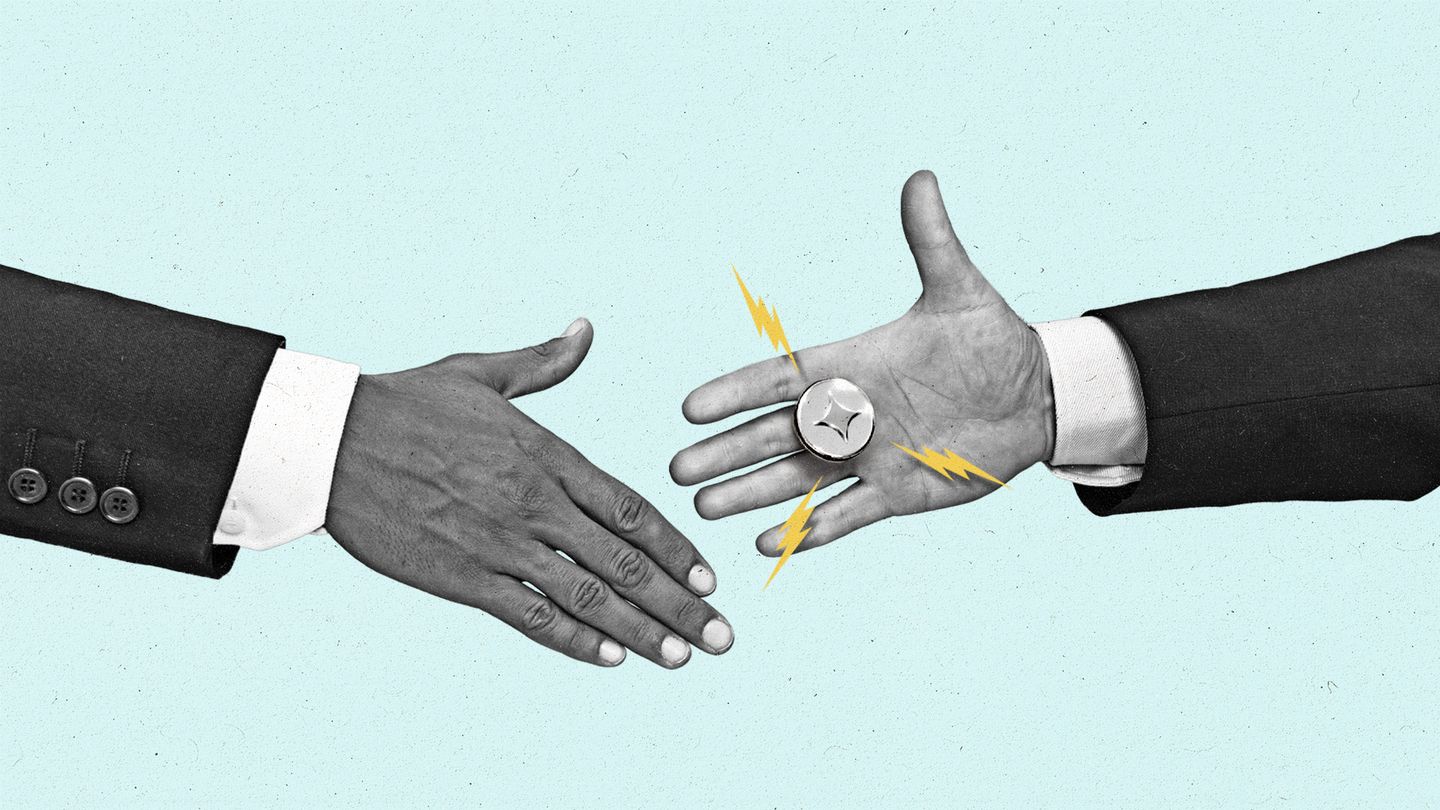 Two hands reaching out for a handshake while one hand is wearing a prank AI buzzer