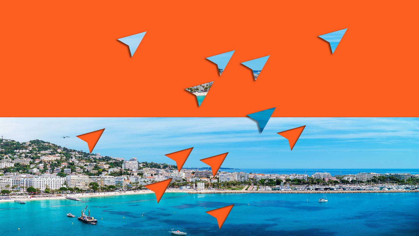 Orange and blue graphic paper mouse cursors flying over a landscape view of Cannes, France