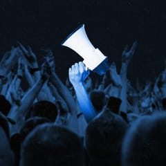 Crowd of fans cheering, with an arm holding up a megaphone amongst them.