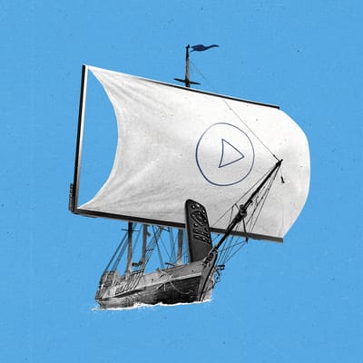 A ship sailing through the water with a streaming remote at the helm.