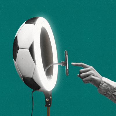 A hand presses a button on a phone sticking out of a ring light shaped like a soccer ball.