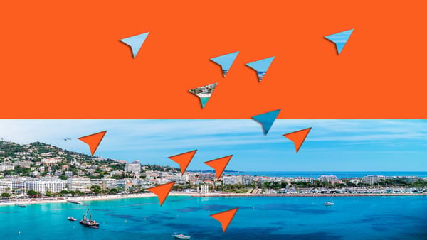 Orange and blue graphic paper mouse cursors flying over a landscape view of Cannes, France